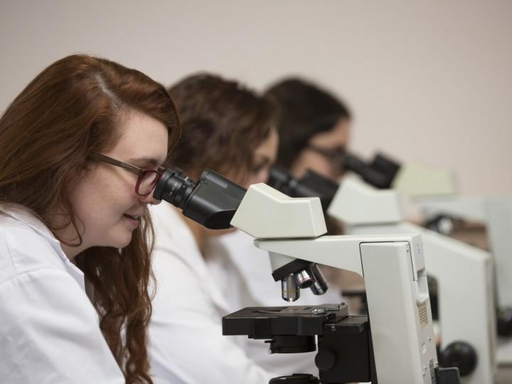 A side view of the students using the microscopes in lab classroom